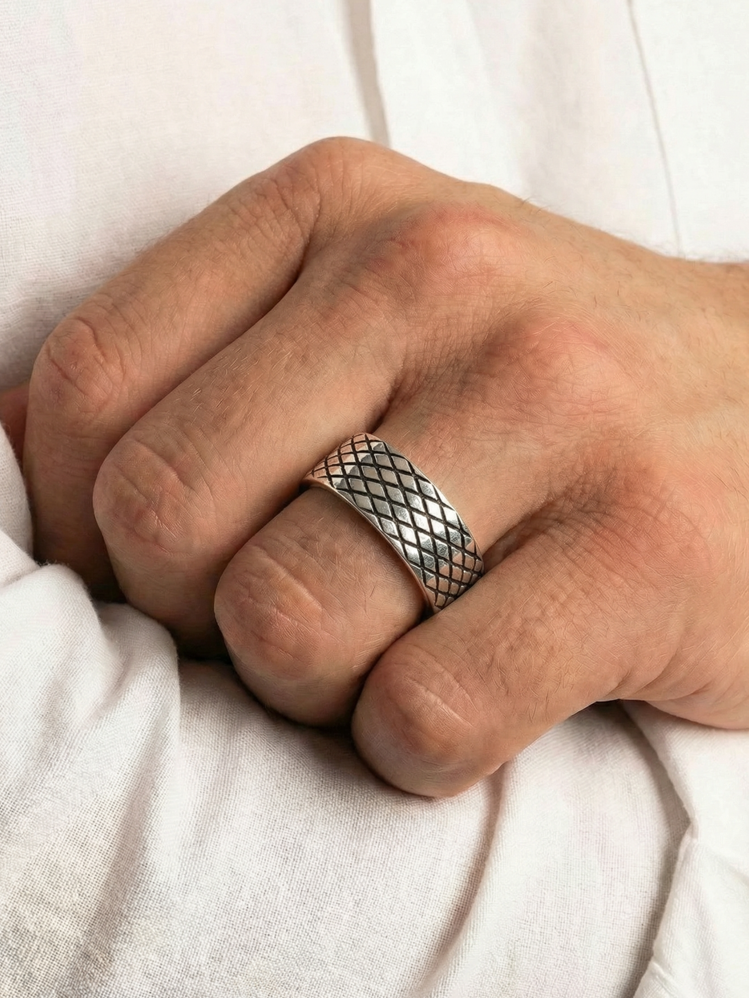 Close up von dem Coryngs Eternal Mesh Ring am Ringfinger von einer Hand, die in der Ellenbogenbeuge liegt