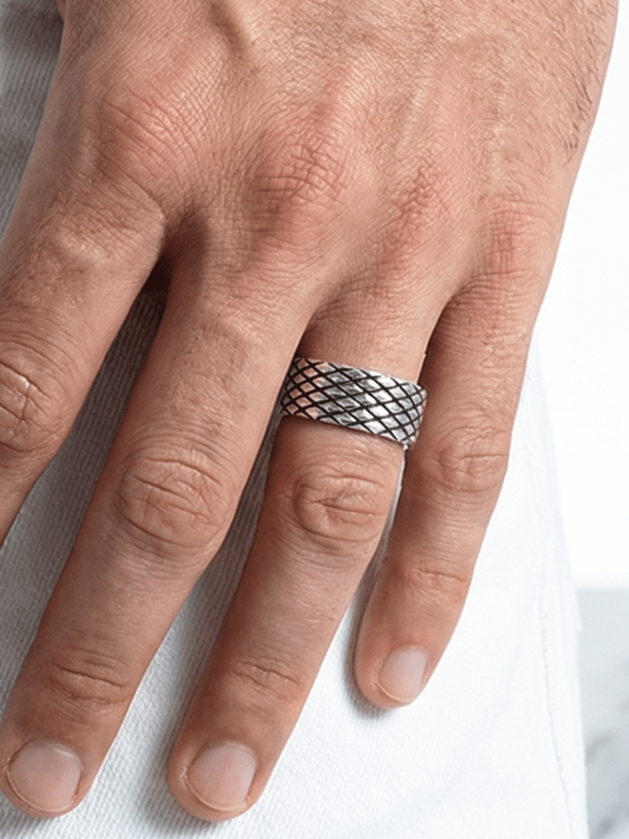 Der Eternal Mesh Ring am Ringfinger von einer Hand, die mit dem Daumen in der Hosentasche steckt
