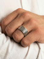 Close up von dem Coryngs Linear Wave Ring am Ringfinger von einer Hand, die in der Ellenbogenbeuge liegt