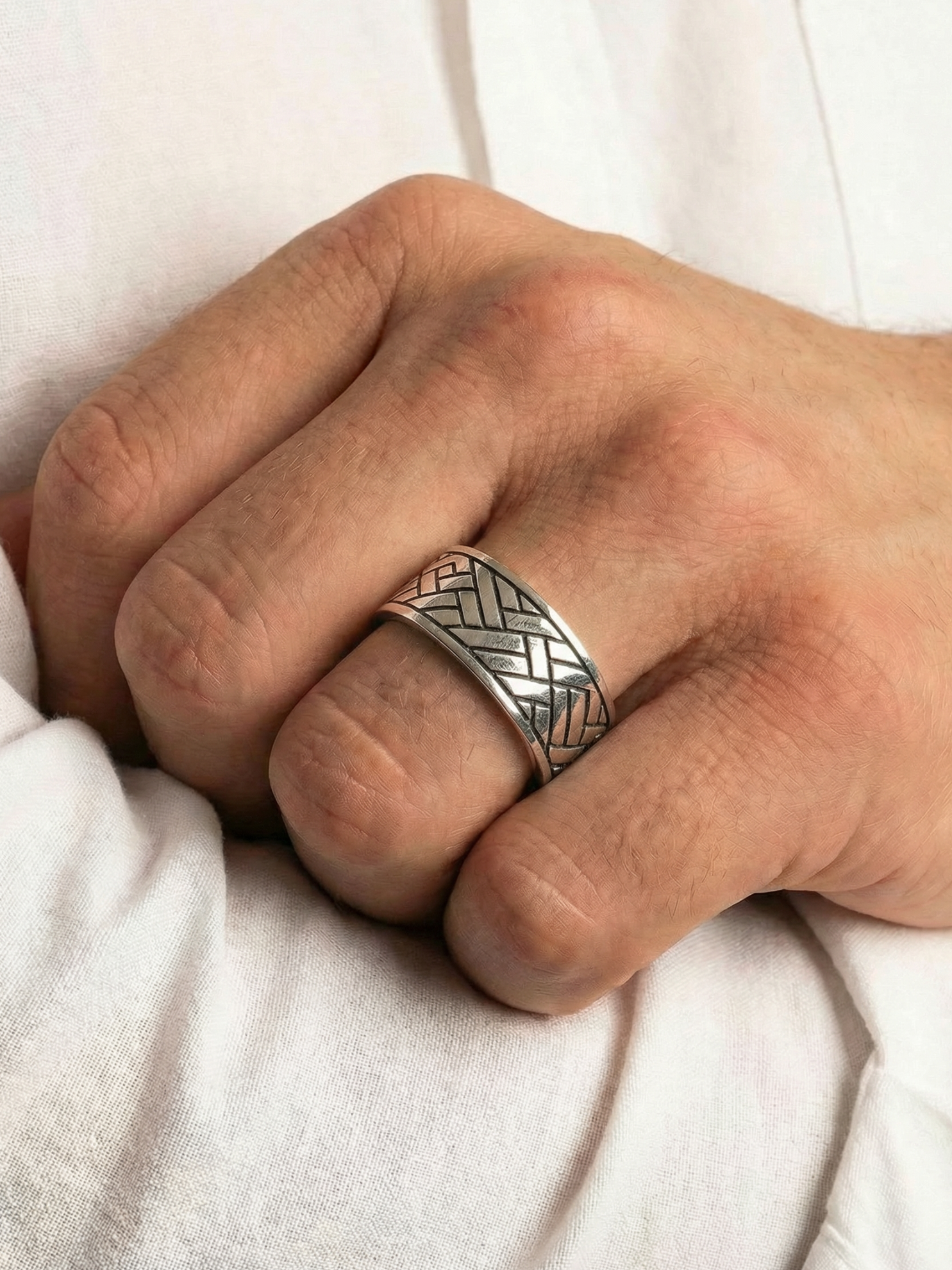 Close up von dem Coryngs Linear Wave Ring am Ringfinger von einer Hand, die in der Ellenbogenbeuge liegt