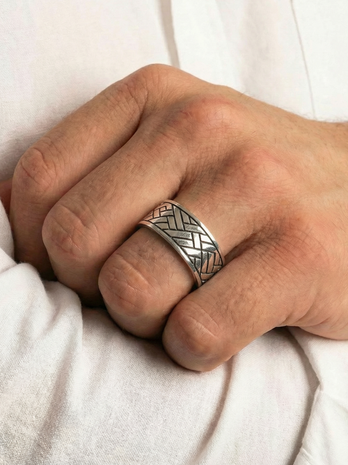 Close up von dem Coryngs Linear Wave Ring am Ringfinger von einer Hand, die in der Ellenbogenbeuge liegt