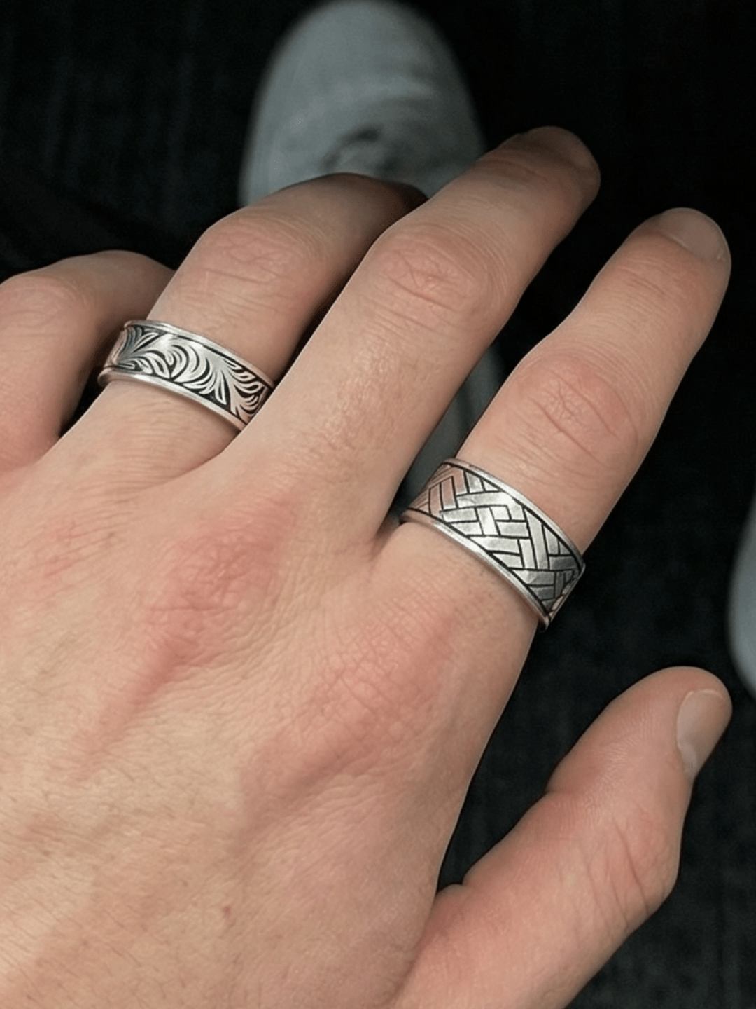 Foto auf dem Der silent garden Ring am Ringfinger getragen wird und der Linear Wave Ring am Zeigefinger getragen wird. Fokus auf dem Linear Wave Ring