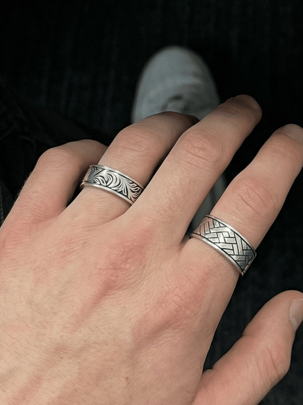 Foto auf dem Der silent garden Ring am Ringfinger getragen wird und der Linear Wave Ring am Zeigefinger getragen wird. Fokus auf dem Silent Garden Ring