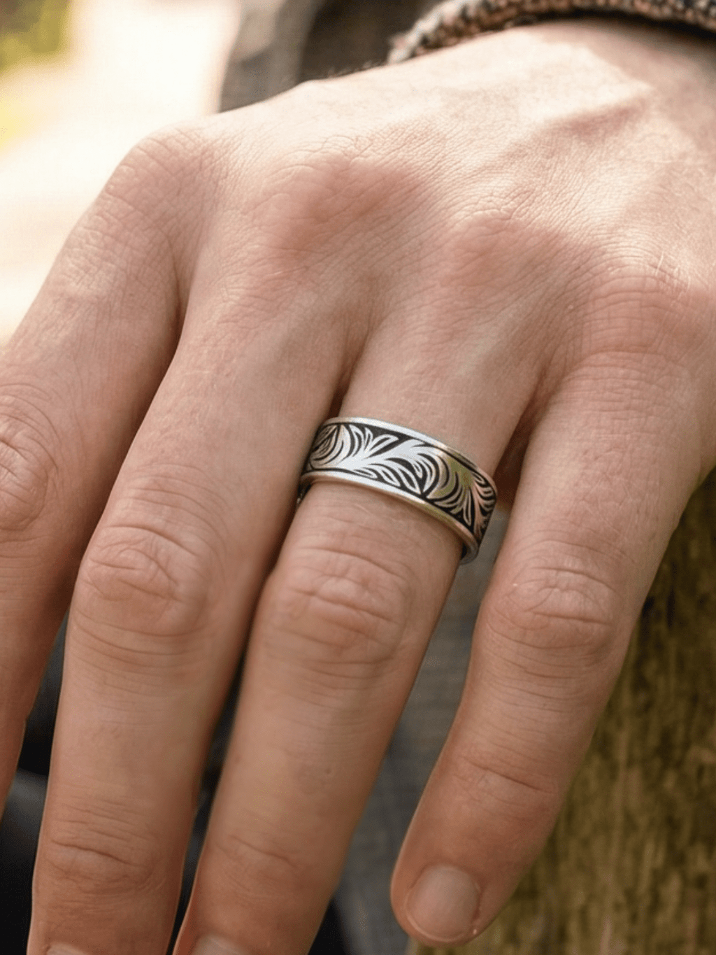 Trafefoto vom Silent garden ring. Die Person sitzt auf einer Bank im Park und hält den Ring in due Kamera